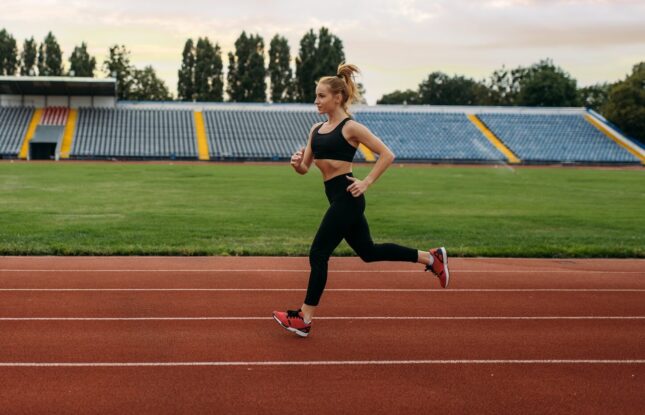 Female runner jogging, training on stadium