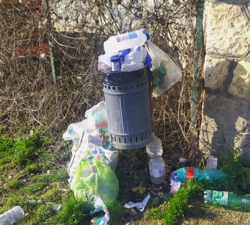 Cestino stracolmo di rifiuti vicino alla fontanella del Monte Salviano