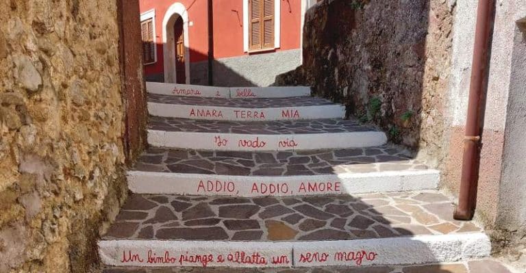 I gradini di una scalinata di Pescocanale accolgono le parole della canzone "Amara terra mia"