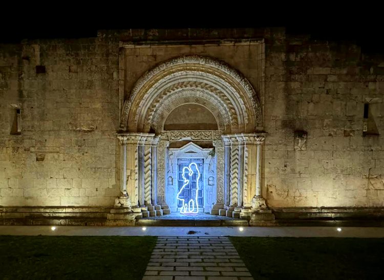 Il prezioso portale di Santa Sabina, a San Benedetto dei Marsi, illuminato da un abbraccio d'amore