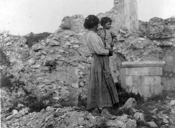 Una donna e il suo bambino circondati da quel che resta di Avezzano distrutta dal terremoto del 1915